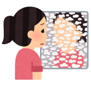 鏡に水垢がこびりついて自分の顔が良く見えない女性